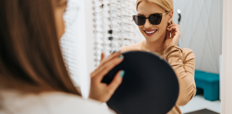 An optician helping a patient select a new pair of sunglasses.