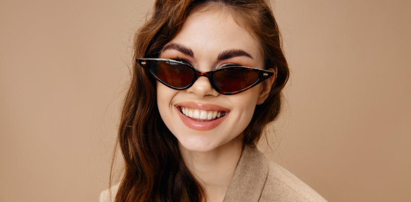A woman with brown hair wearing thin, pointed tortoiseshell cat eye sunglasses.