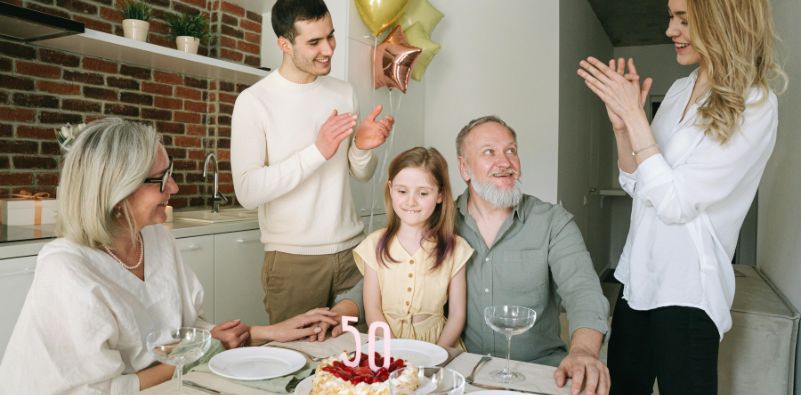 A family singing Happy Birthday to the Grandad around the dining table