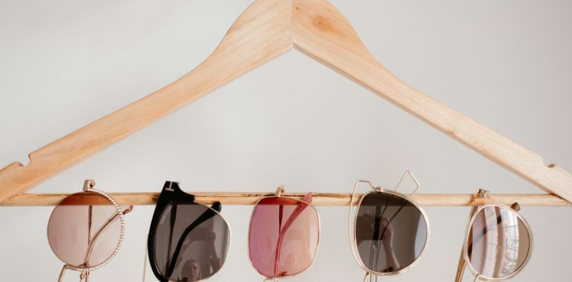 5 different styles of glasses hung on a wooden hanger